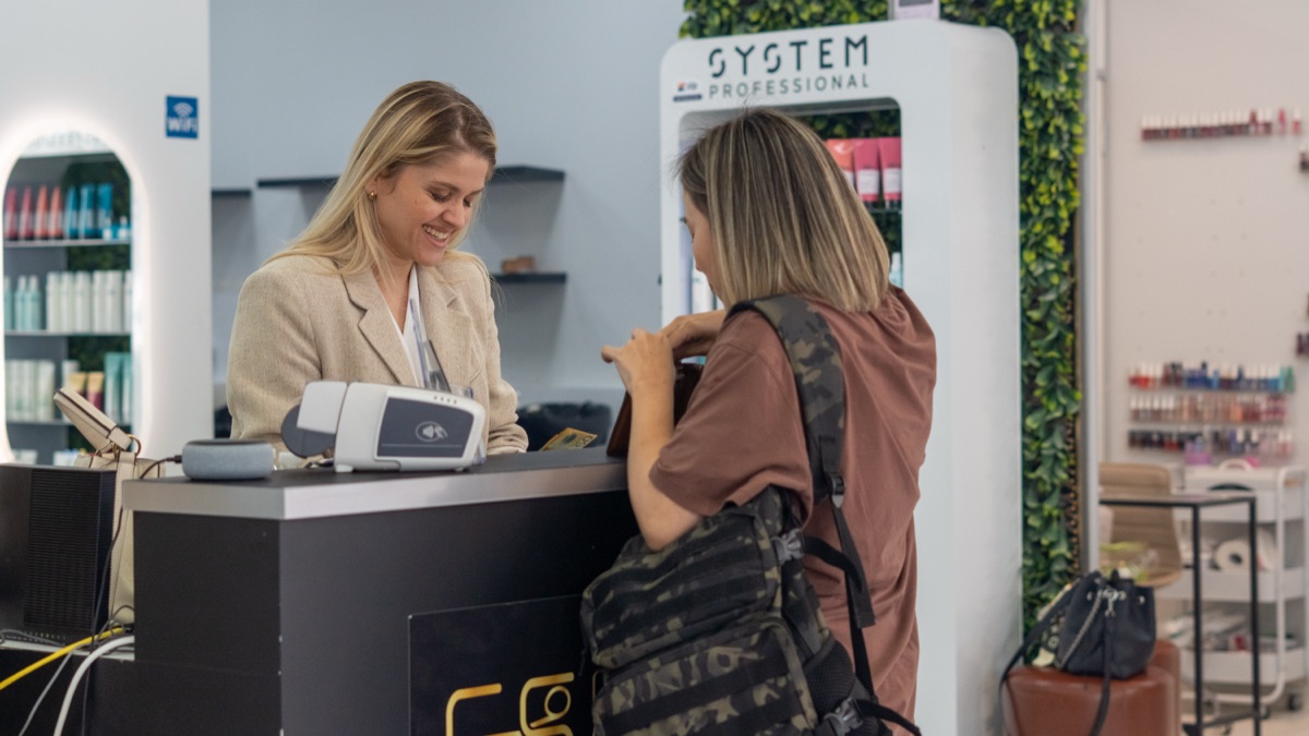 Gleyce Kelly welcoming a client at Creative Square salon reception in Fortitude Valley